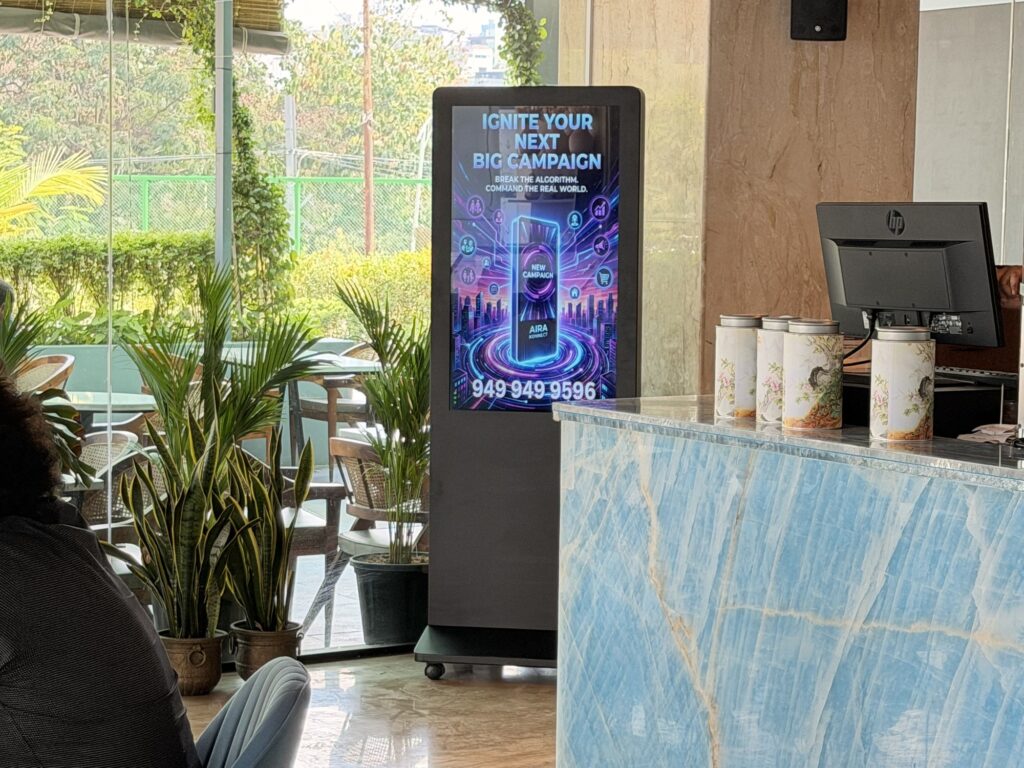 Aira Konnect advertising screen beside a blue marble counter and indoor plants at Caffe Jubilee.
