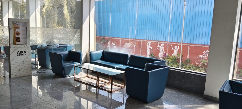 Aira Konnect display beside blue sofas and a glass coffee table at Gymkhana Club, Jubilee Hills.